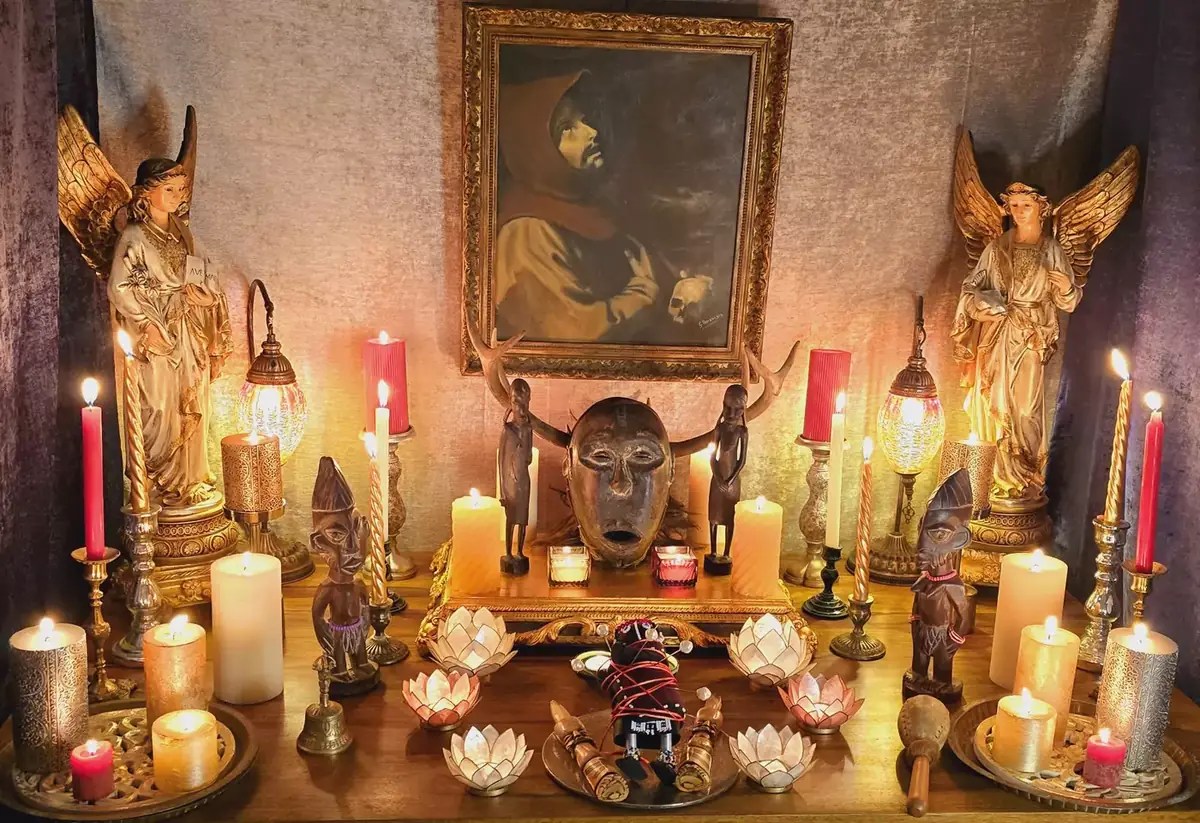 Altare con angeli dorati, maschera rituale e lumi di loto
