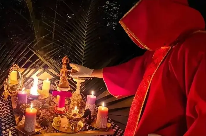 Il Maestro in tunica rossa officia un rituale all'aperto